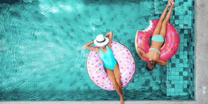 donna e bambina in piscina con materassino