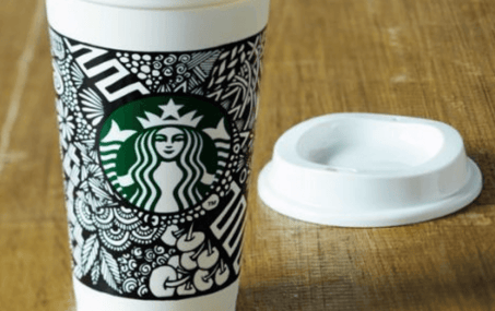 Tazza di Starbucks decorata da una partecipante al concorso. Bicchiere bianco con fantasia floreale e in stile mandala disegnati con una penna nera
