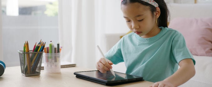 bambina asiatica disegna su tablet