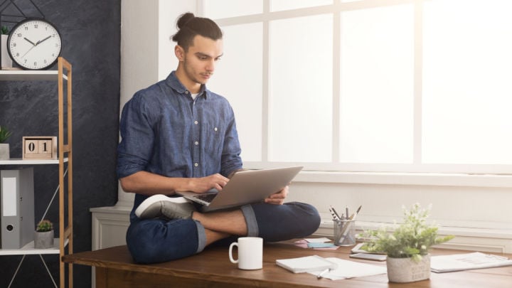 uomo a gambe incrociate (mezzo loto) con laptop