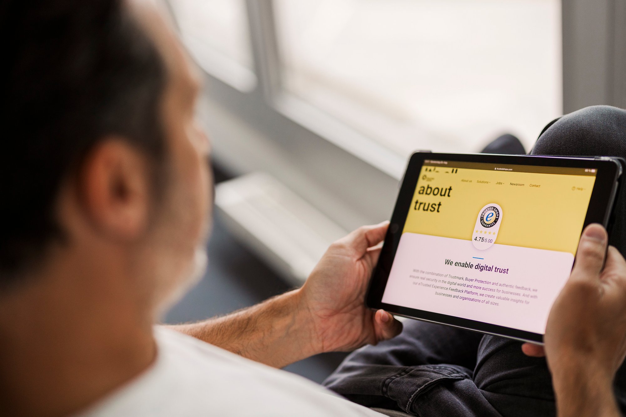 Persona che utilizza un tablet con la schermata della homepage di Trusted Shops