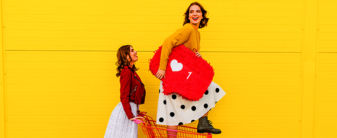 donna ha in mano un oggetto con forma di like di Instagram